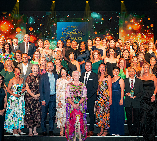 Group of people standing on a stage, the winners of the 2025 WA Health excellence awards.