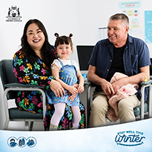 Parents with their toddler sitting in a vaccination clinic