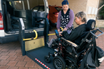 Person in wheelchair using lift to get into a van