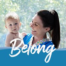 Nurse holding a baby with the word 'Belong' over the top of the image