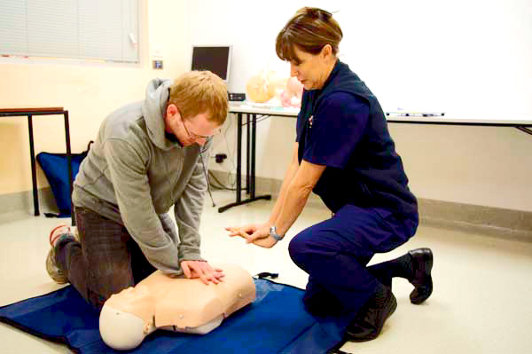 People performing CPR on mannequin