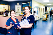 Two nurses looking through procedure's manual