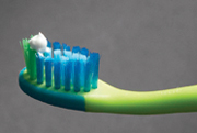 Close view of a toothbrush head featuring a pea-sized portion of toothpaste