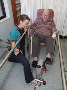 Man participating in rehabilitation therapy with help of physiotherapist