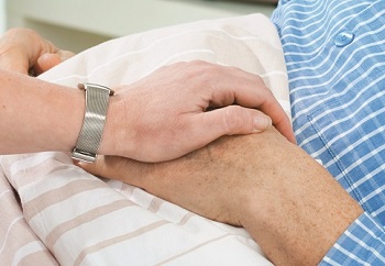 Hands being held on hospital bed