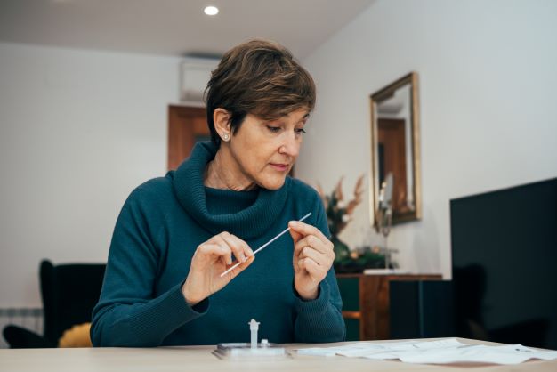 Woman testing herself with rapid antigen test