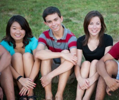 Group of high school students sitting on the grass