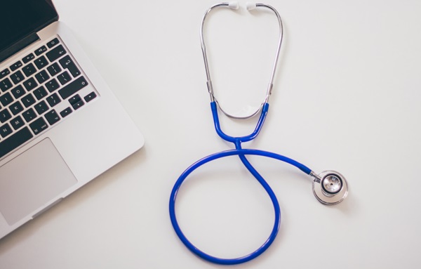 Apple Macbook and stethoscope on desk