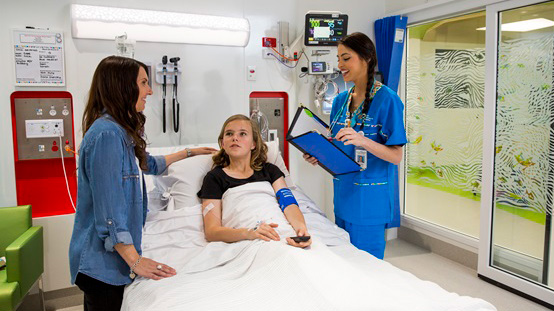 Mother, child and nurse in hospital room